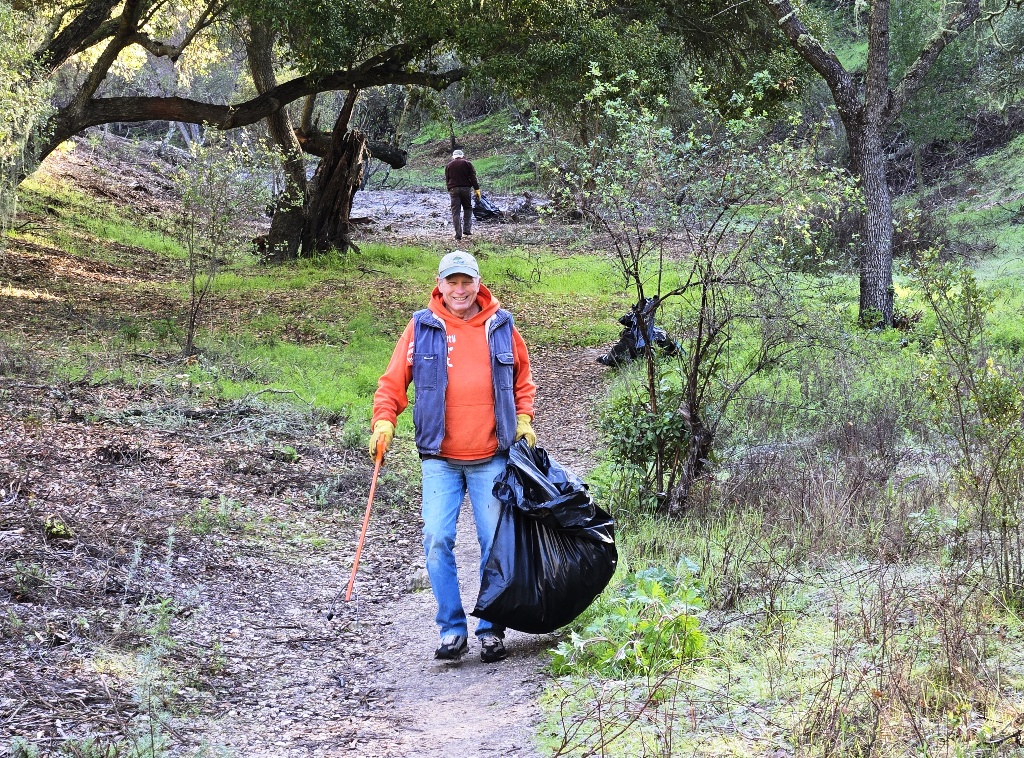 Removing bags of trash from the cleared ravine